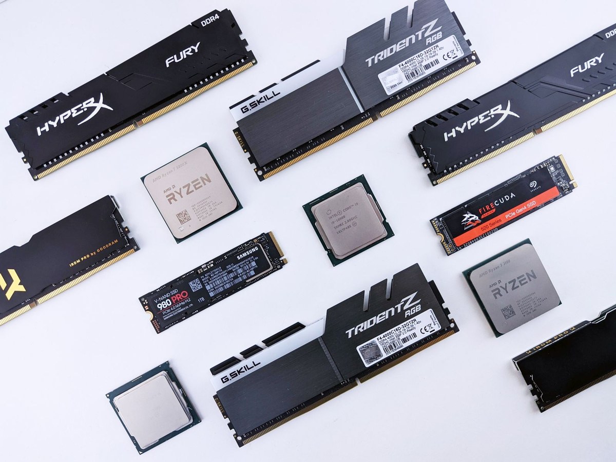 桌上摊开的内存条、AMD 锐龙处理器、三星 990 PRO 与希捷 FireCuda 固态硬盘