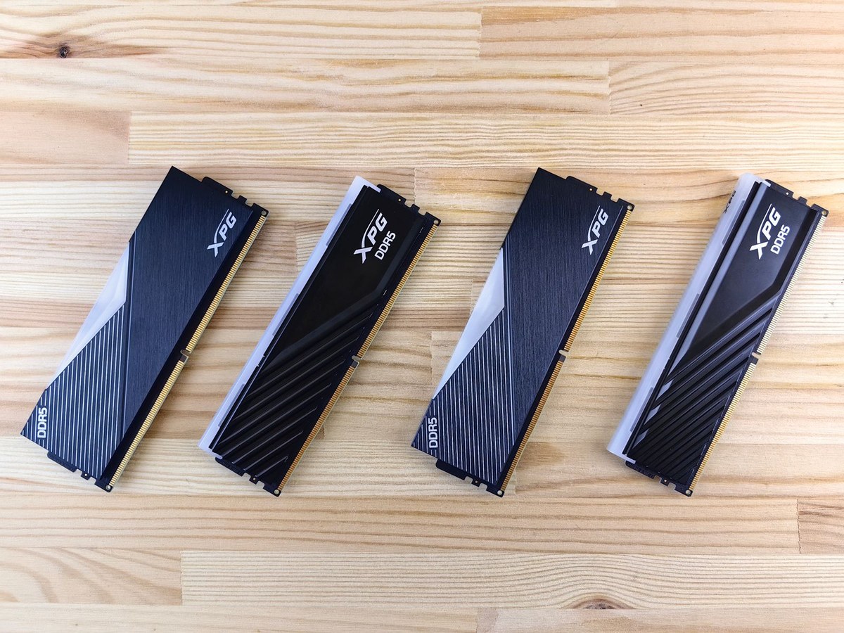 四条 DDR5 内存条并排放在木纹桌面上